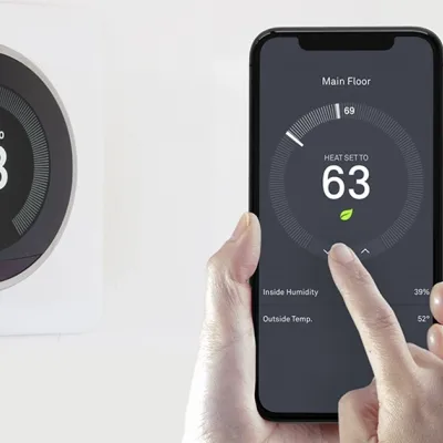 A person using a smart phone application saving energy with a wireless smart thermostat on a white background.